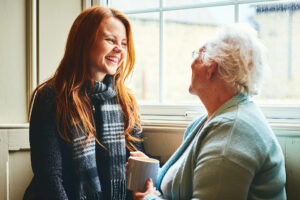Young woman talking with senior woman about senior care solutions.