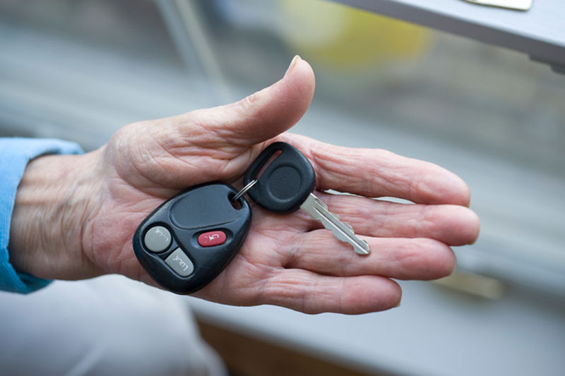 senior hand holding car keys