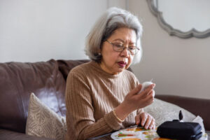 An older woman tests her blood glucose levels, an essential step to help older adults manage diabetes.